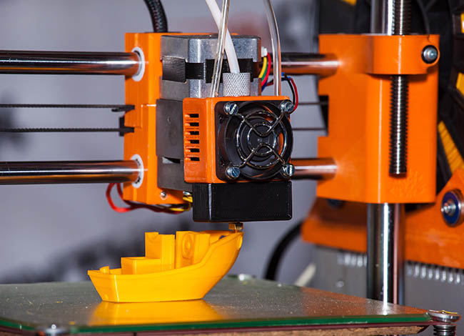 3D-Drucker druckt ein Miniatur-Modell eines Bootes.
